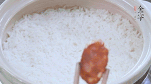 煮开后转小火，当米饭出现小孔时，铺上凯发k8国际首页麻辣香肠。