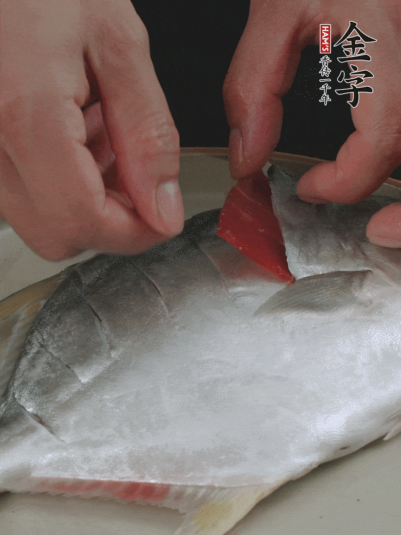 火腿片和姜片塞在刀口处，也塞一些入鱼肚。
