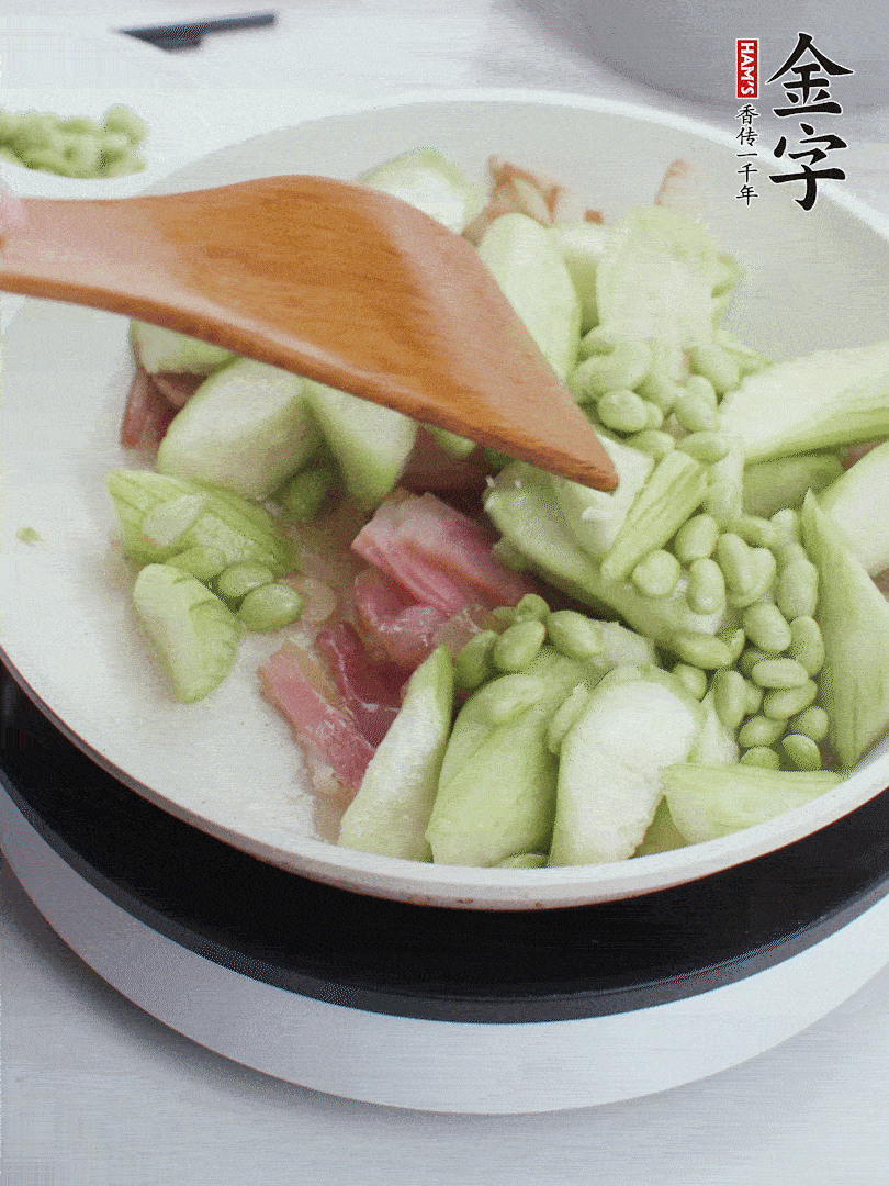 依次下丝瓜、青豆翻炒，炒至丝瓜打蔫缩小。