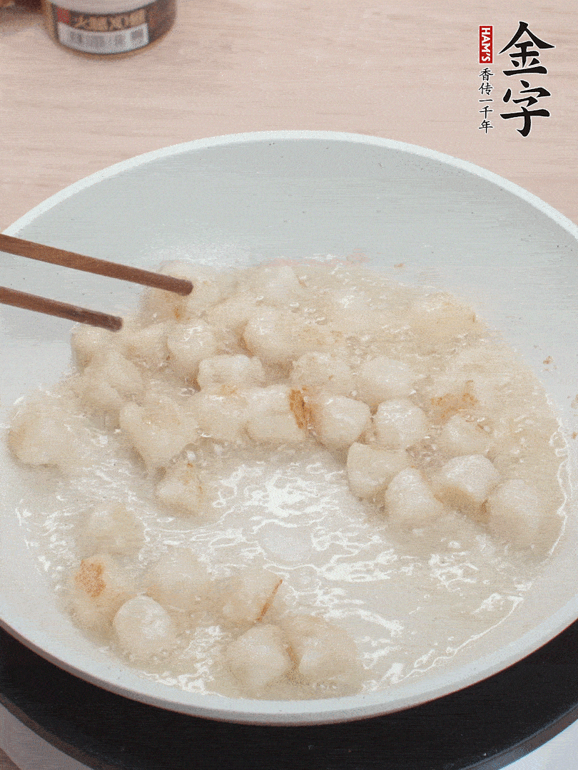 油温4成热，鲜贝蘸干淀粉下锅煎，一面微黄后翻面。