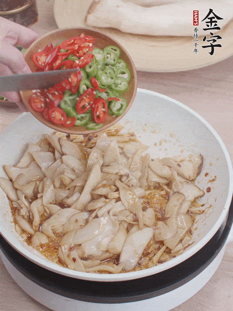 下杏鲍菇、青红辣椒炒出香味。