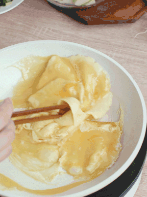 油6成热时，下鸡蛋液，边缘凝固时翻拌成块状。