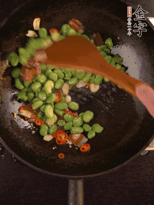 再下蚕豆煸炒，加1勺料酒调味。