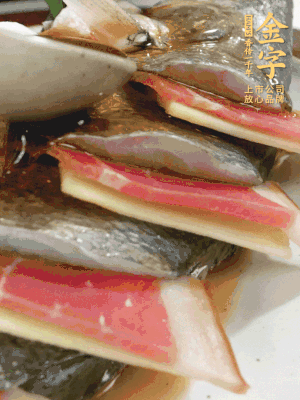 鱼肚中塞葱结、火腿片，鱼身上码放姜片、火腿片，倒入混合的料汁。