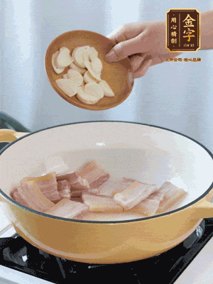 热油下咸肉煸出香味，加蒜片、毛豆翻炒均匀